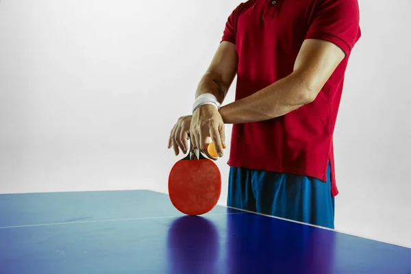 Young man playing table tennis on white studio background — Stockfoto
