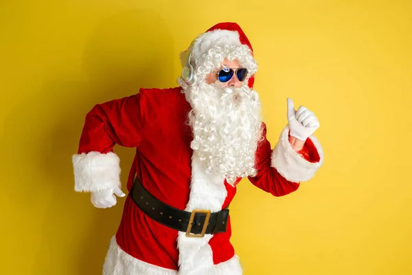 Санта Клаус з сучасними окулярами, ізольованими на жовтому тлі студії — стокове фото