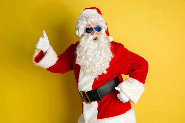 Kerstman met moderne bril geïsoleerd op gele studio achtergrond — Stockfoto