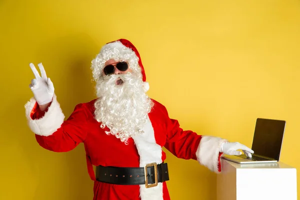 Babbo Natale con gadget moderni isolati su sfondo giallo studio — Foto Stock