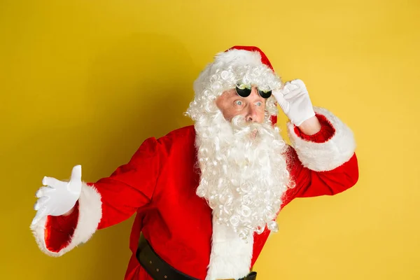 Santa Claus con gafas de vista modernas aisladas sobre fondo estudio amarillo — Foto de Stock