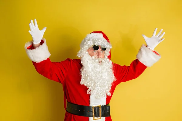 Weihnachtsmann mit moderner Brille isoliert auf gelbem Studiohintergrund — Stockfoto