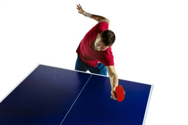 Genç adam beyaz stüdyo arka planında masa tenisi oynuyor.