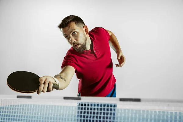 Giovane uomo che gioca a ping pong su sfondo bianco studio — Foto Stock