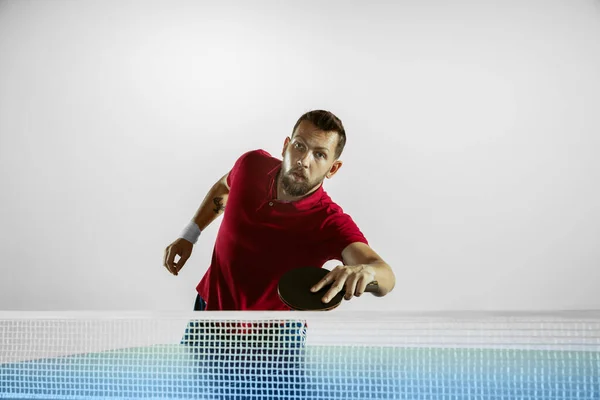 Joven jugando al tenis de mesa sobre fondo blanco del estudio —  Fotos de Stock