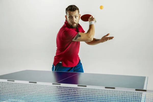 Joven jugando al tenis de mesa sobre fondo blanco del estudio —  Fotos de Stock