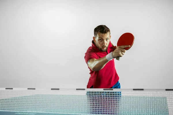 Joven jugando al tenis de mesa sobre fondo blanco del estudio — Foto de Stock