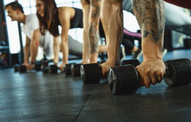 Spor salonunda spor yapan bir grup kaslı sporcu.