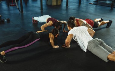 Spor salonunda spor yapan bir grup kaslı sporcu.