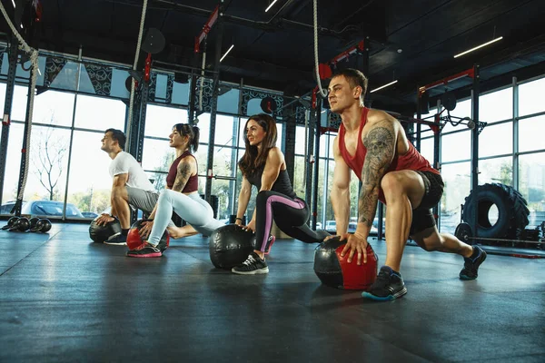 Grupa muskularnych sportowców ćwiczy na siłowni — Zdjęcie stockowe