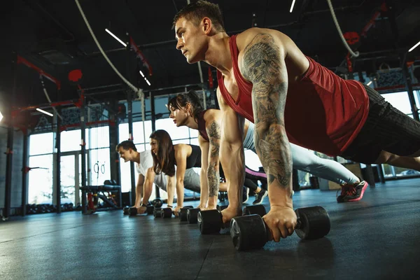 Un grupo de atletas musculares haciendo ejercicio en el gimnasio — Foto de Stock