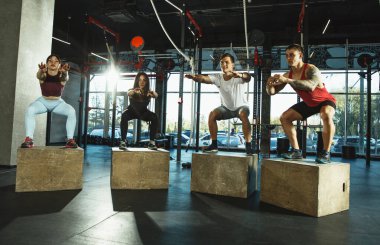 Spor salonunda spor yapan bir grup kaslı sporcu.