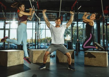 Spor salonunda spor yapan bir grup kaslı sporcu.