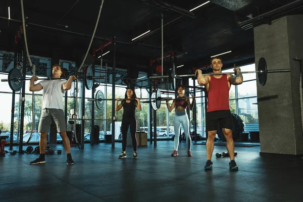 Un grupo de atletas musculares haciendo ejercicio en el gimnasio — Foto de Stock