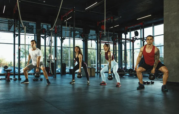 Eine Gruppe muskulöser Athleten beim Training im Fitnessstudio — Stockfoto