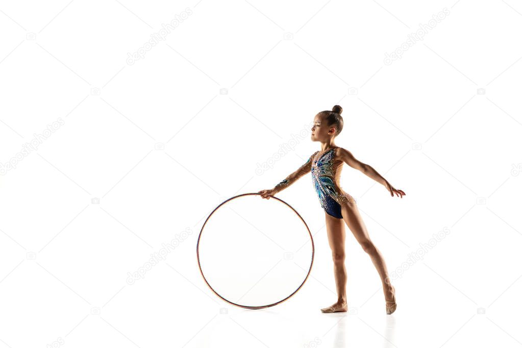 Little flexible female gymnast isolated on white studio background