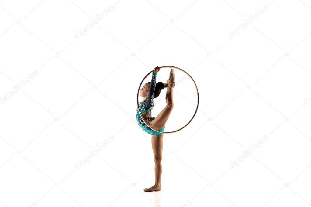 Little flexible female gymnast isolated on white studio background