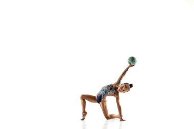 Küçük esnek bayan jimnastikçi beyaz stüdyo arka planında izole edilmiş.