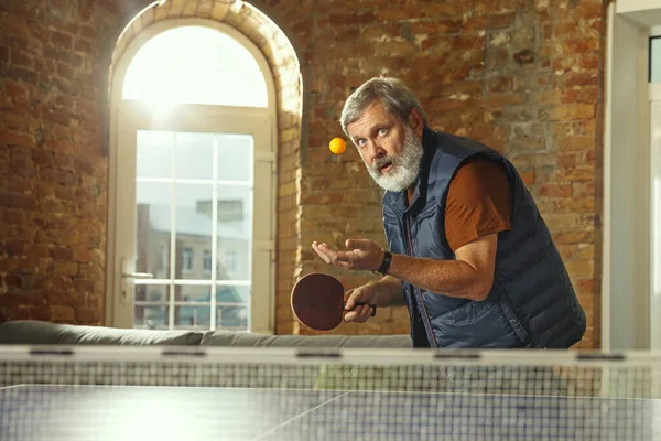 Uomo anziano che gioca a ping pong sul posto di lavoro, divertirsi — Foto Stock
