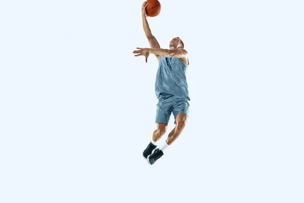 Jonge Kaukasische basketbalspeler tegen witte studio achtergrond — Stockfoto