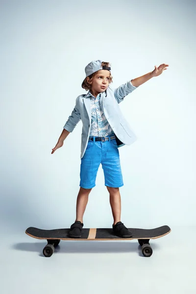 Mooie jonge jongen op skateboard in casual kleding op witte studio achtergrond — Stockfoto