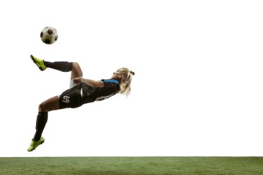 Kadın futbolcu stadyumda topa tekme atıyor