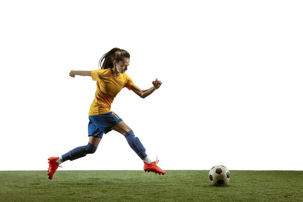 Female soccer player kicking ball at the stadium