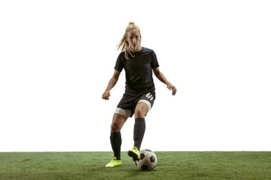 Kadın futbolcu stadyumda topa tekme atıyor