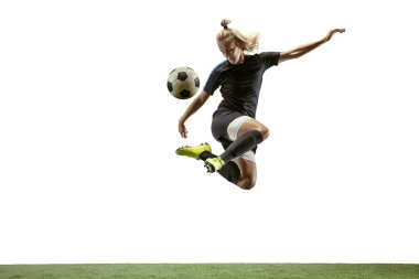 Kadın futbolcu stadyumda topa tekme atıyor