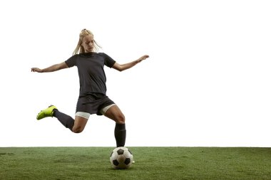 Kadın futbolcu stadyumda topa tekme atıyor