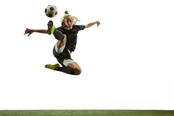 Female soccer player kicking ball at the stadium