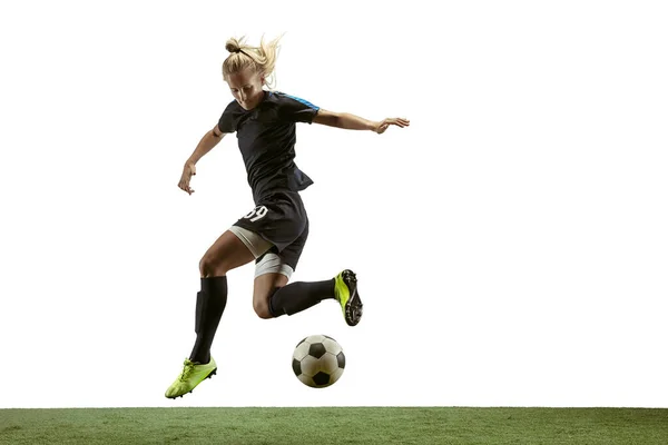 Female soccer player kicking ball at the stadium