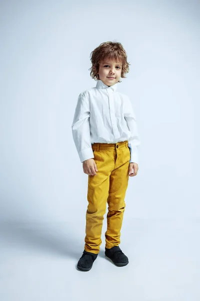 Rapaz bonito em roupas casuais no fundo do estúdio branco — Fotografia de Stock