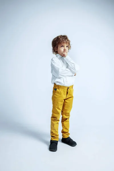 Ładny młody chłopiec w luźnych ubraniach na białym tle studio — Zdjęcie stockowe