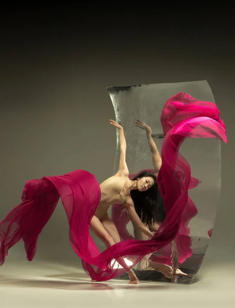 Young and stylish modern ballet dancer on brown background