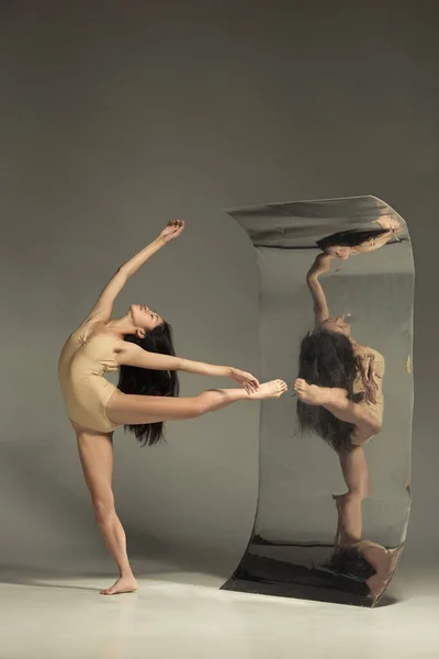 Young and stylish modern ballet dancer on brown background