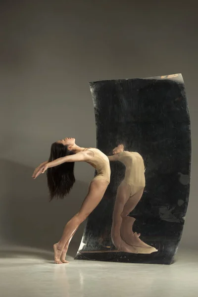 Молодой и стильный современный артист балета на коричневом фоне — стоковое фото