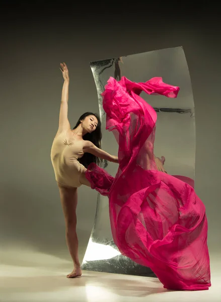 Jovem e elegante moderno bailarino de balé no fundo marrom — Fotografia de Stock