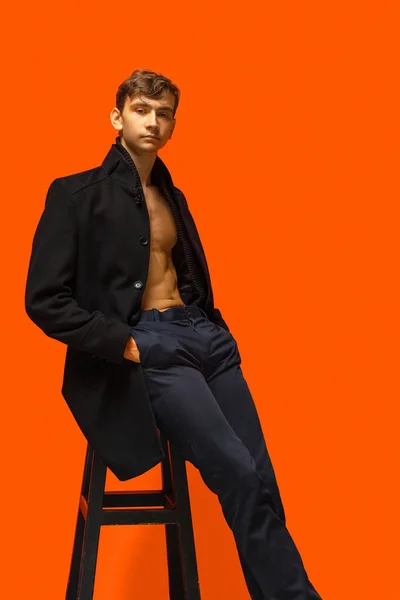 Komean nuoren miehen muotokuva oranssilla taustalla — kuvapankkivalokuva