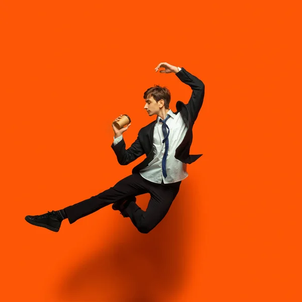 Günlük ofis tarzı giyinmiş bir adam stüdyo arka planında tek başına zıplıyor. — Stok fotoğraf