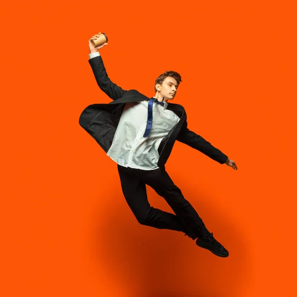 Man in casual office style clothes jumping isolated on studio background — Stock Photo, Image