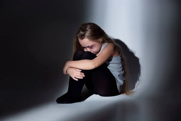 Triste e assustada menina com sangue e olhos machucados sentado com medo — Fotografia de Stock