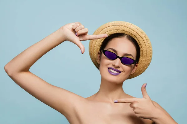 Porträtt av vacker ung kvinna med ljusa make-up isolerad på blå studio bakgrund — Stockfoto