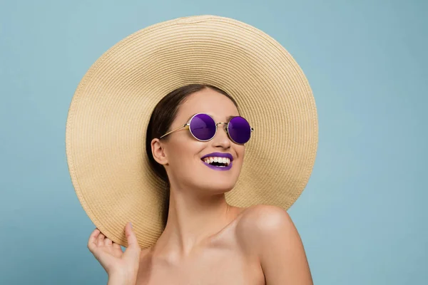 Portret van mooie jonge vrouw met heldere make-up geïsoleerd op blauwe studio achtergrond — Stockfoto