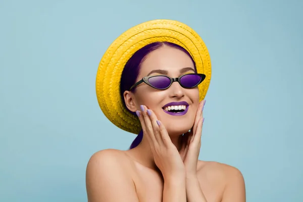 Porträtt av vacker ung kvinna med ljusa make-up isolerad på blå studio bakgrund — Stockfoto