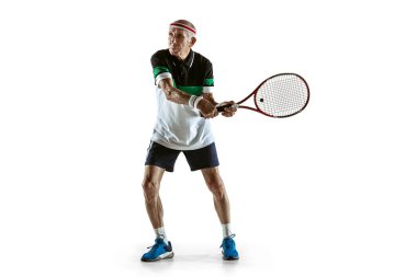 Beyaz arka planda tek başına tenis oynayan son sınıf öğrencisi.