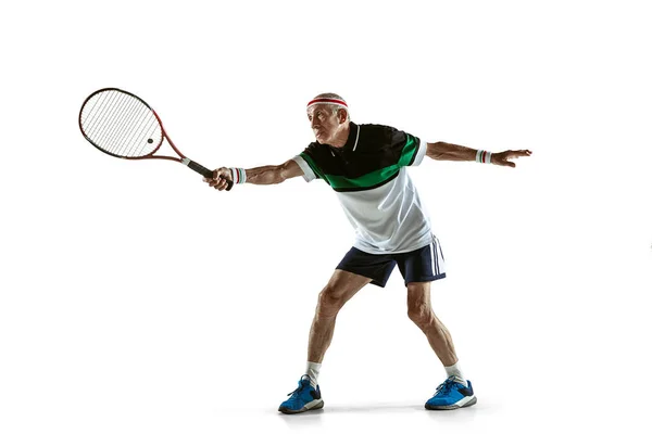 Hombre mayor jugando tenis en ropa deportiva aislado sobre fondo blanco —  Fotos de Stock