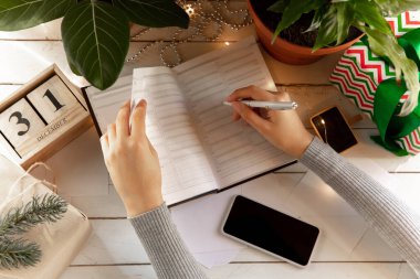 Dilekler, hayaller ve hedefler yazar, Yılbaşı ve Noel için plan yapar.