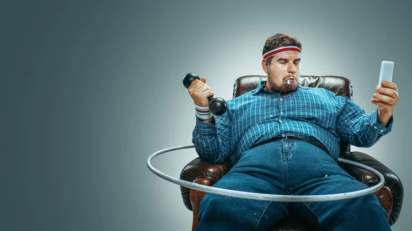 Gordo sentado em uma poltrona marrom, emocional assistindo TV — Fotografia de Stock