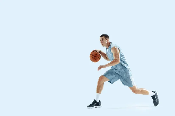 Jonge Kaukasische basketbalspeler tegen witte studio achtergrond — Stockfoto